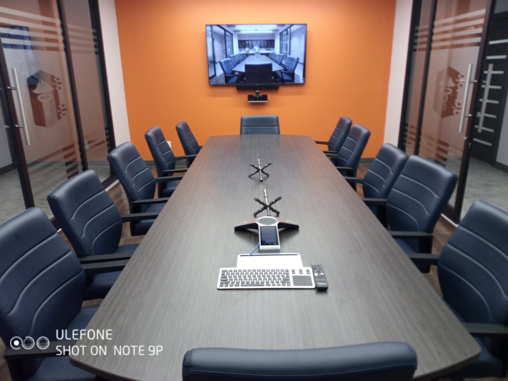 Commercial conference room with a wall display and table microphone system