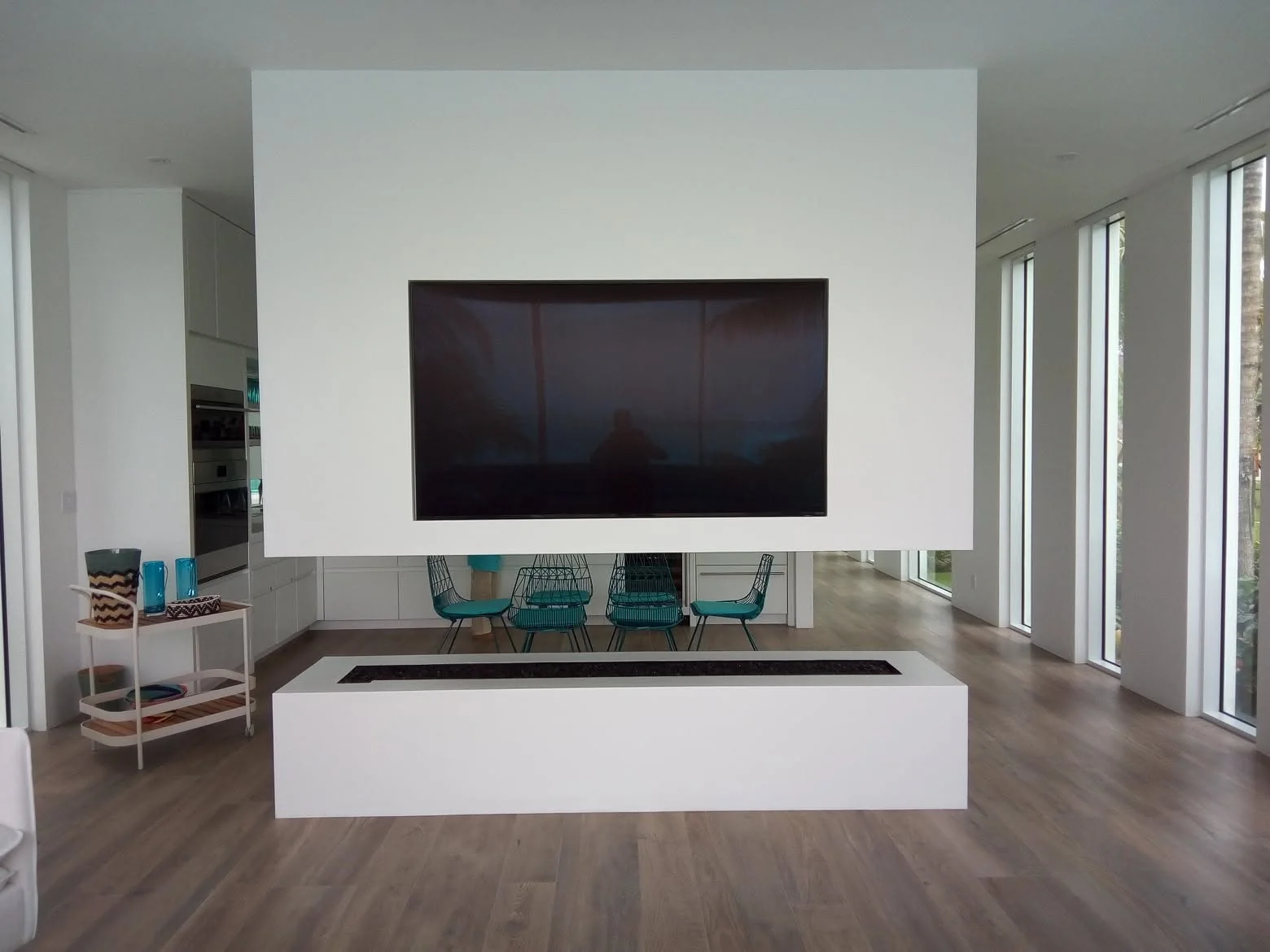 Minimal contemporary living room with a television recessed into an architectural feature wall