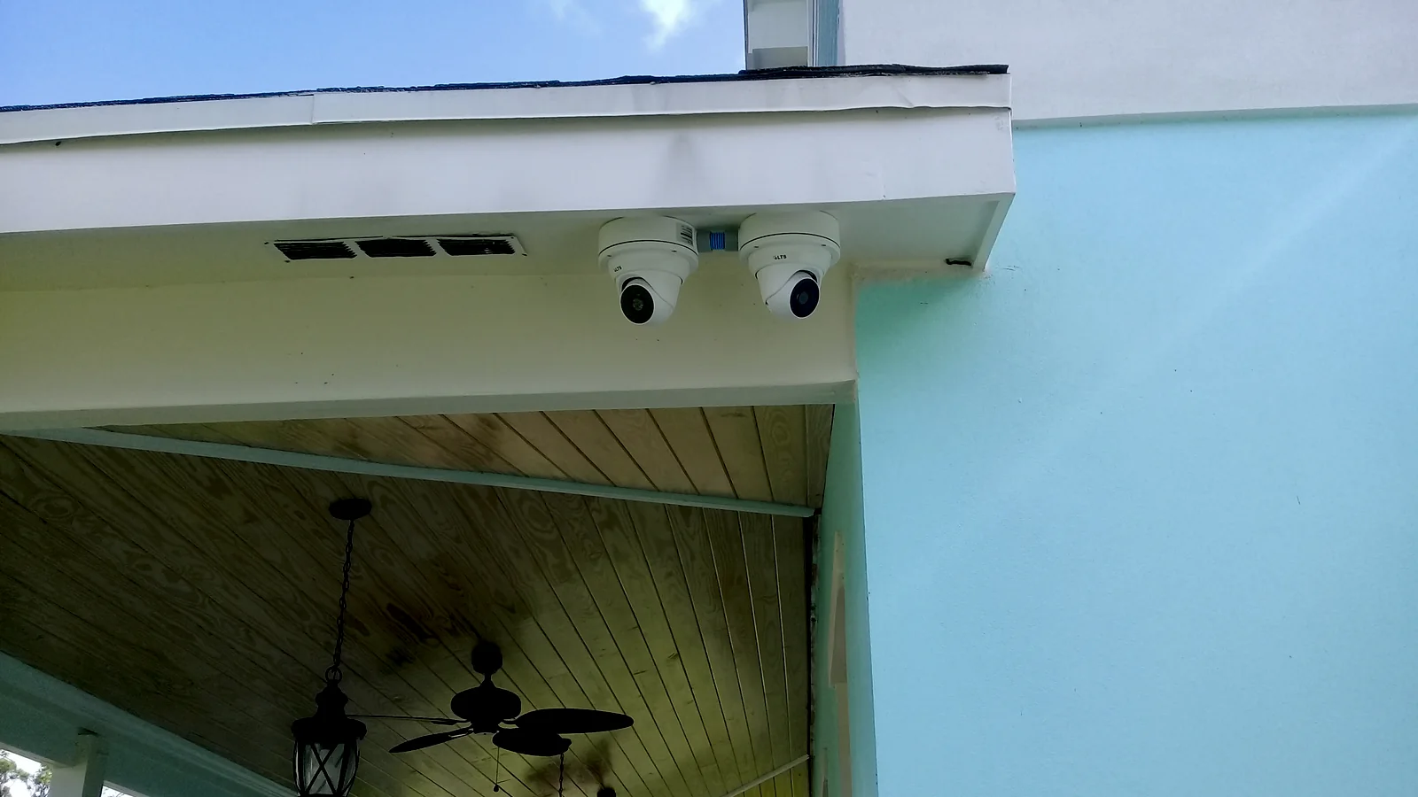 Exterior security cameras installed high beneath a residential roofline